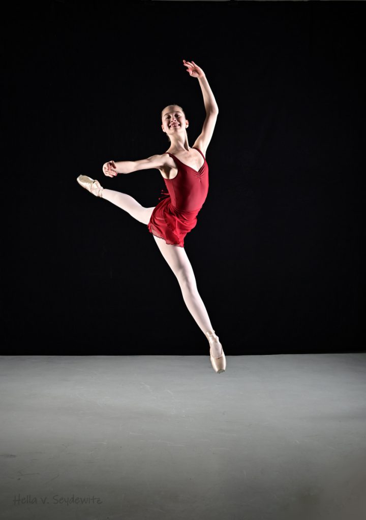 Ballerina in rotem Kleid in Sprung