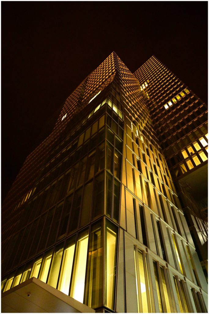 Nächtliches Hochhaus in Frankfurt. Es leuchtet von innen heraus golden.