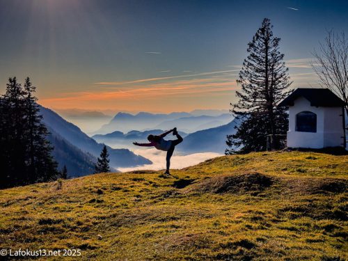 eine Frau macht Yoga auf einen Berg