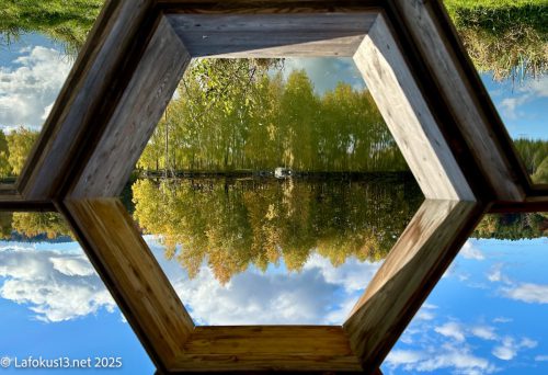 Spiegelung eines Sees durch ein Fenster fotografiert