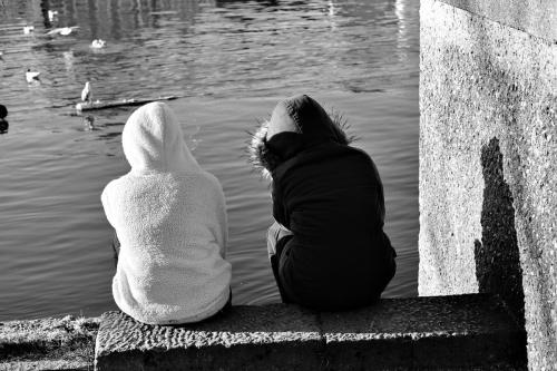 Zwei Personen schauen auf einen See.
