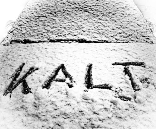 das Wort "kalt" in den Schnee auf einer Motorhaube geschrieben