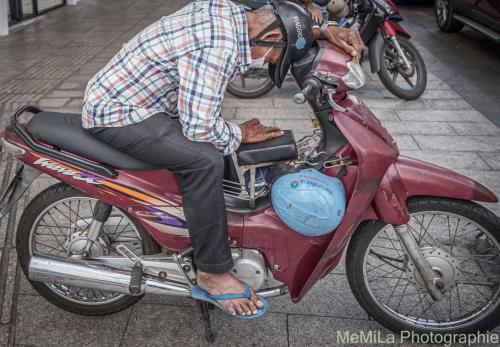 eine Person macht ein Nickerchen auf ein Motorrad.