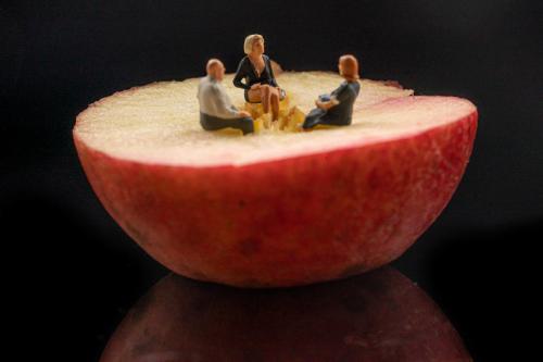 Kleine Figuren auf Apfel sitzend