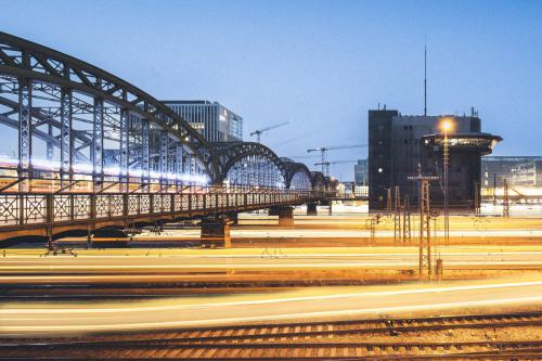 Langzeitaufnahme von Zügen, man sieht nur den gelben Lichtschein, links ist die Hackerbrücke.