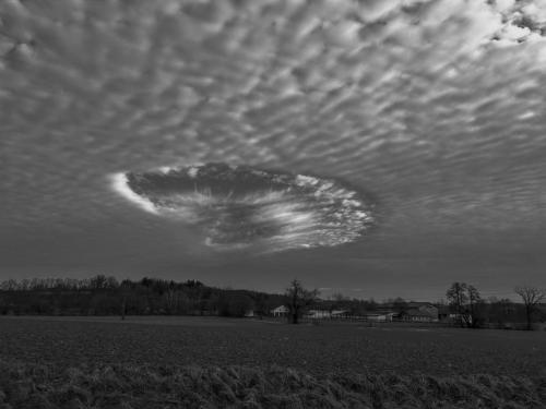 Ein Wolkenbild, das in der Mitte ein kreisrundes Phänomen hat.