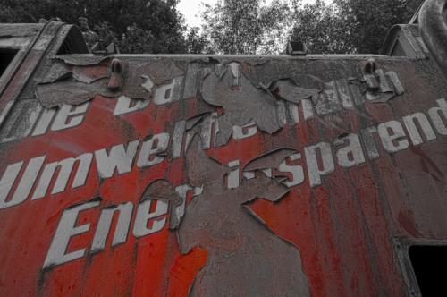 Die Ausschrift einer ausgemusterten Rangierlok. Der Slogan "Die Bahn Umweltfreundlich Energiesparend" blättert mit der roten Lackierung ab. Bild ist in SW, aber die rote Lackierung wurde wieder sichtbar gemacht.
